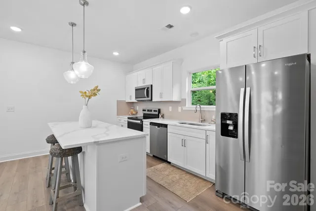 a kitchen that has a refrigerator a sink and a stove