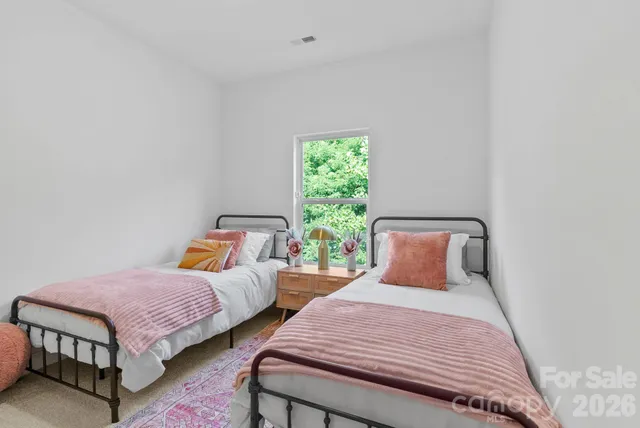 a bedroom with two beds and a potted plant