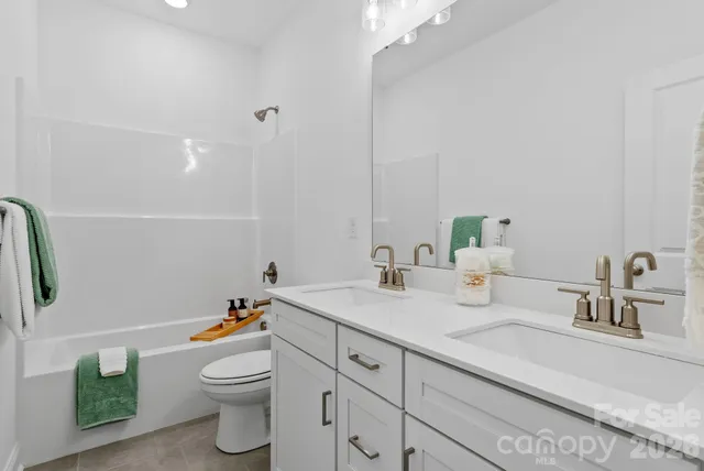 a bathroom with a granite countertop sink mirror vanity and toilet