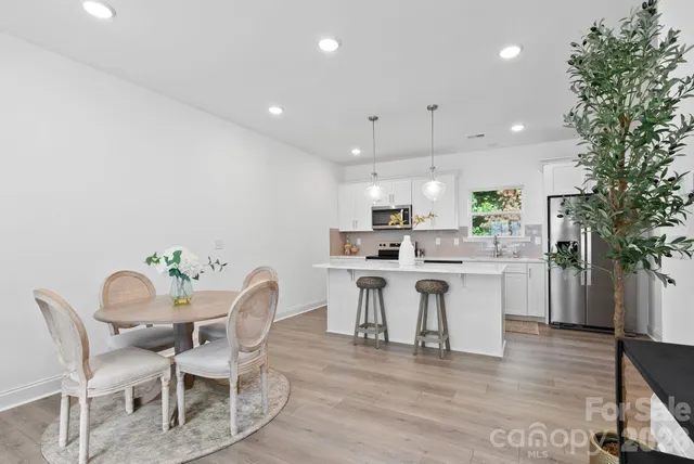 a kitchen with kitchen island a white counter top space a sink cabinets and a potted plant