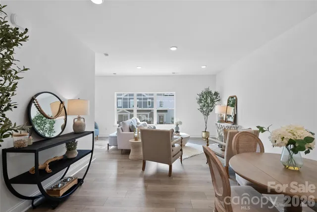 a living room with furniture a rug potted plant and a window