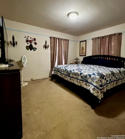 a bedroom with a bed dresser and a window