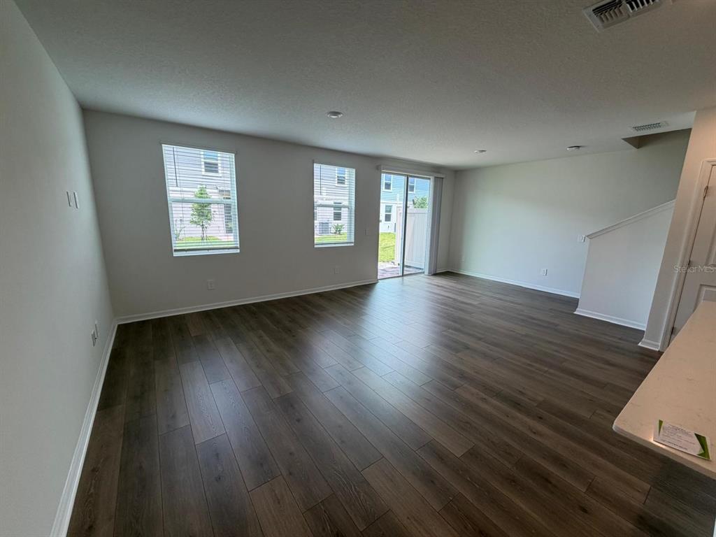 4244 Ranch House Road St. Cloud, FL 34772 - Photo 7 of 34 an empty room with wooden floor and windows