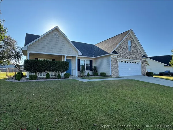 a front view of a house with a garden and trees