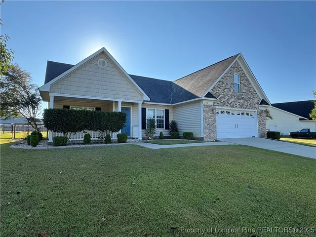 a front view of a house with a garden and trees