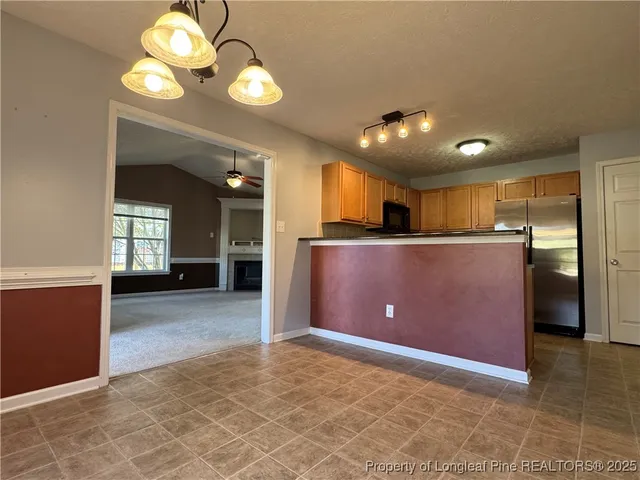 a view of kitchen with refrigerator and window