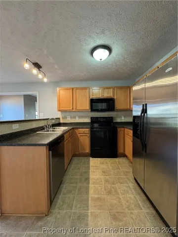 a kitchen with kitchen island granite countertop a sink and a stove