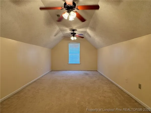 an empty room with a ceiling fan and a window