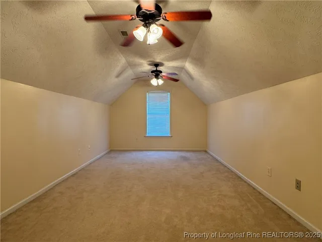 an empty room with a ceiling fan and a window