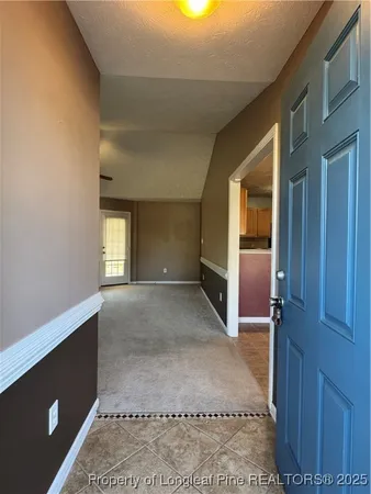 an empty room with fireplace chandelier fan and windows