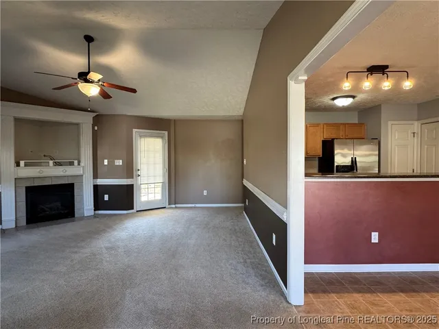 an empty room with windows and fireplace