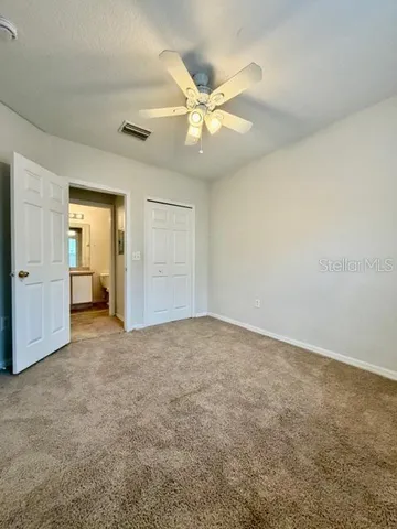 an empty room with closet and fan