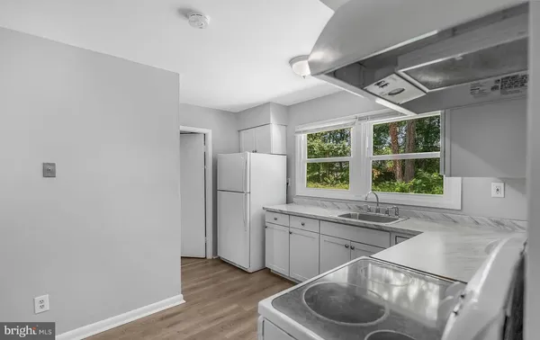 a kitchen with cabinets appliances a sink and a window