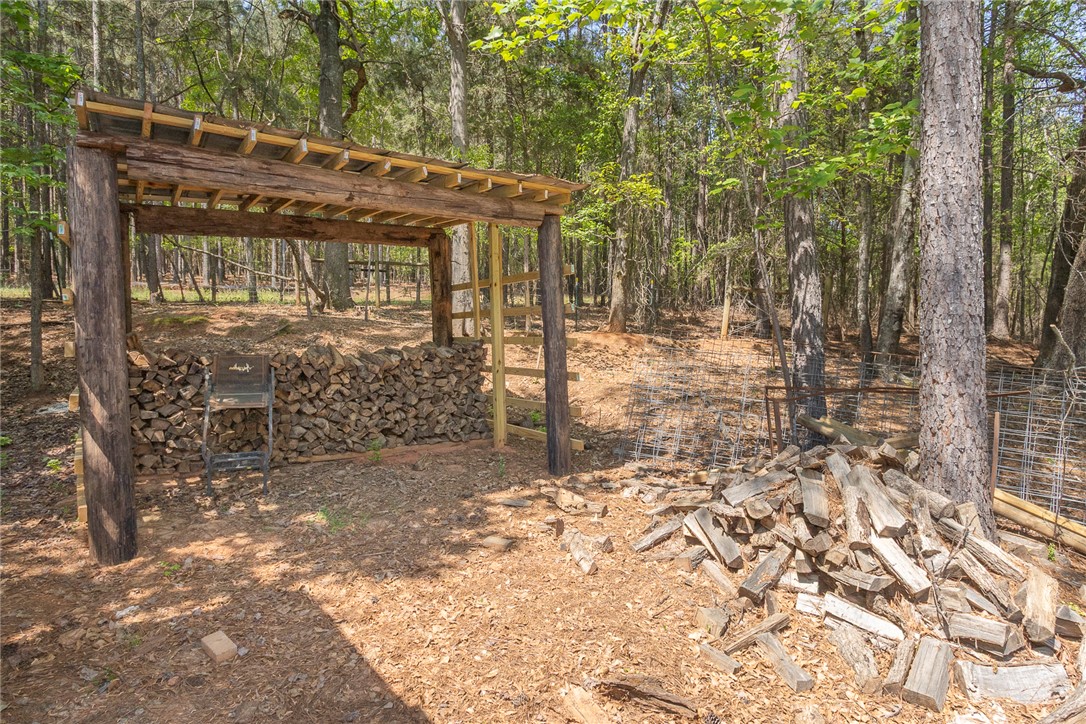 820 Travis Road Anderson, SC 29626 - Photo 41 of 46 This rustic wood storage area offers practical utility amidst a natural, wooded setting.