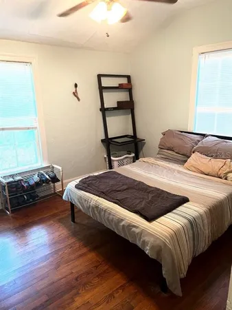 a bedroom with a bed and wooden floor
