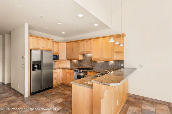 a kitchen with stainless steel appliances granite countertop a stove a refrigerator and a refrigerator