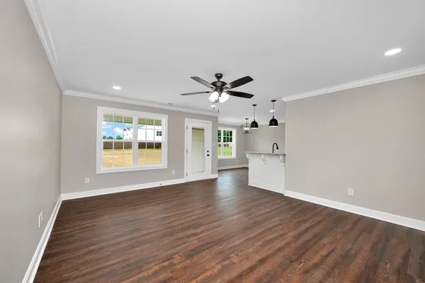 a view of an empty room with a window and wooden floor