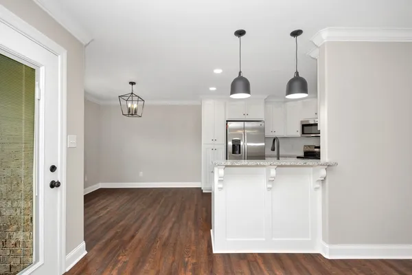 a view of a kitchen with wooden floor and window