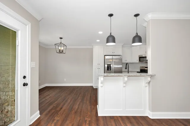 a view of a kitchen with wooden floor and window