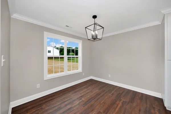 a view of empty room with wooden floor and window