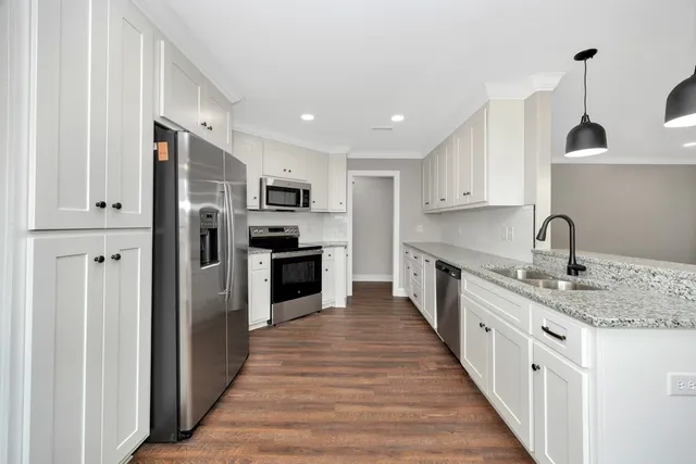 a large kitchen with stainless steel appliances granite countertop a refrigerator and a sink