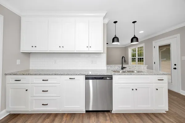a kitchen with granite countertop white cabinets and a stove