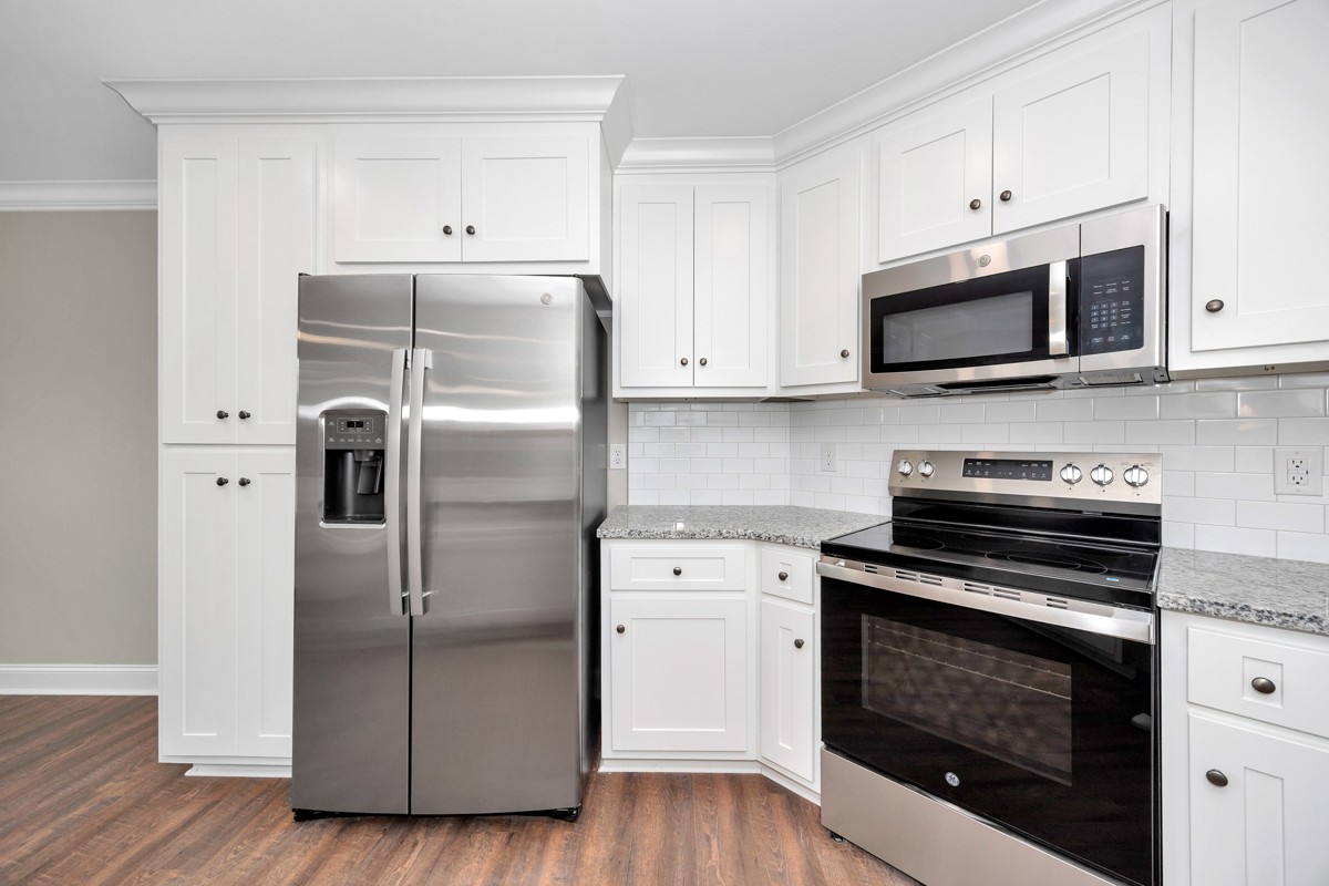 27025 North Wales Road Elkmont, AL 35620 - Photo 22 of 40 a kitchen with cabinets stainless steel appliances and wooden floor