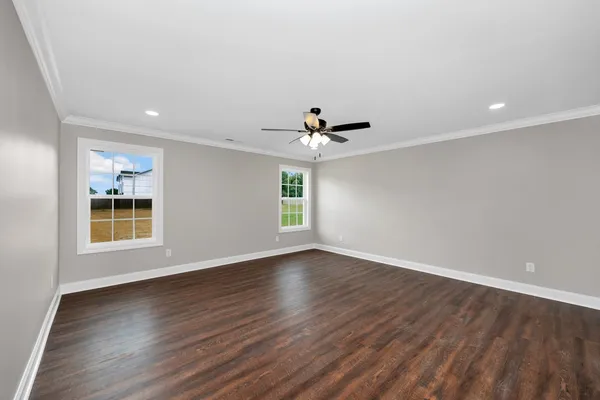 a view of an empty room with a window and wooden floor