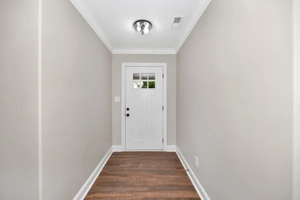 a view of a hallway with wooden floor