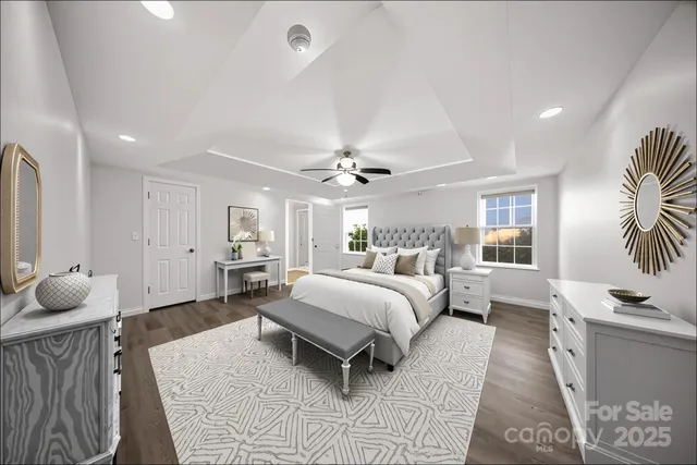 a spacious bedroom with a bed a chandelier and glass door