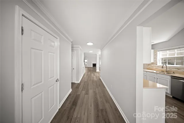 a view of a hallway with wooden floor and a living room
