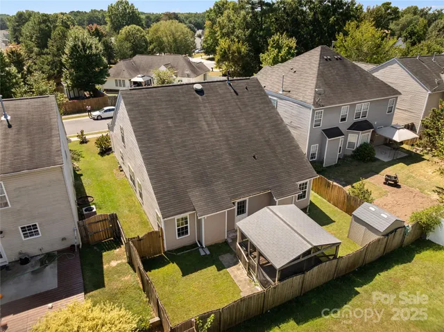 an aerial view of a house with swimming pool and large trees