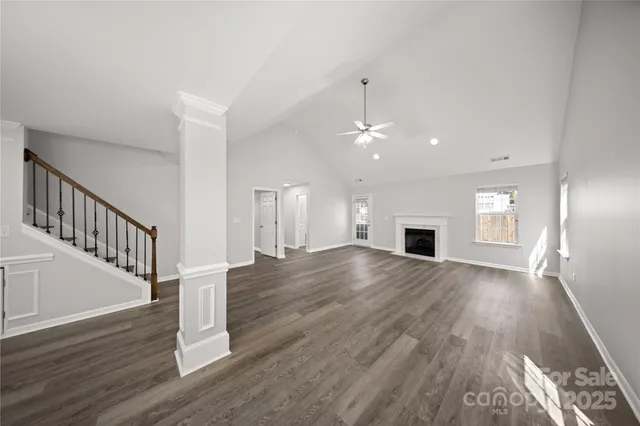 a view of empty room with wooden floor and fireplace