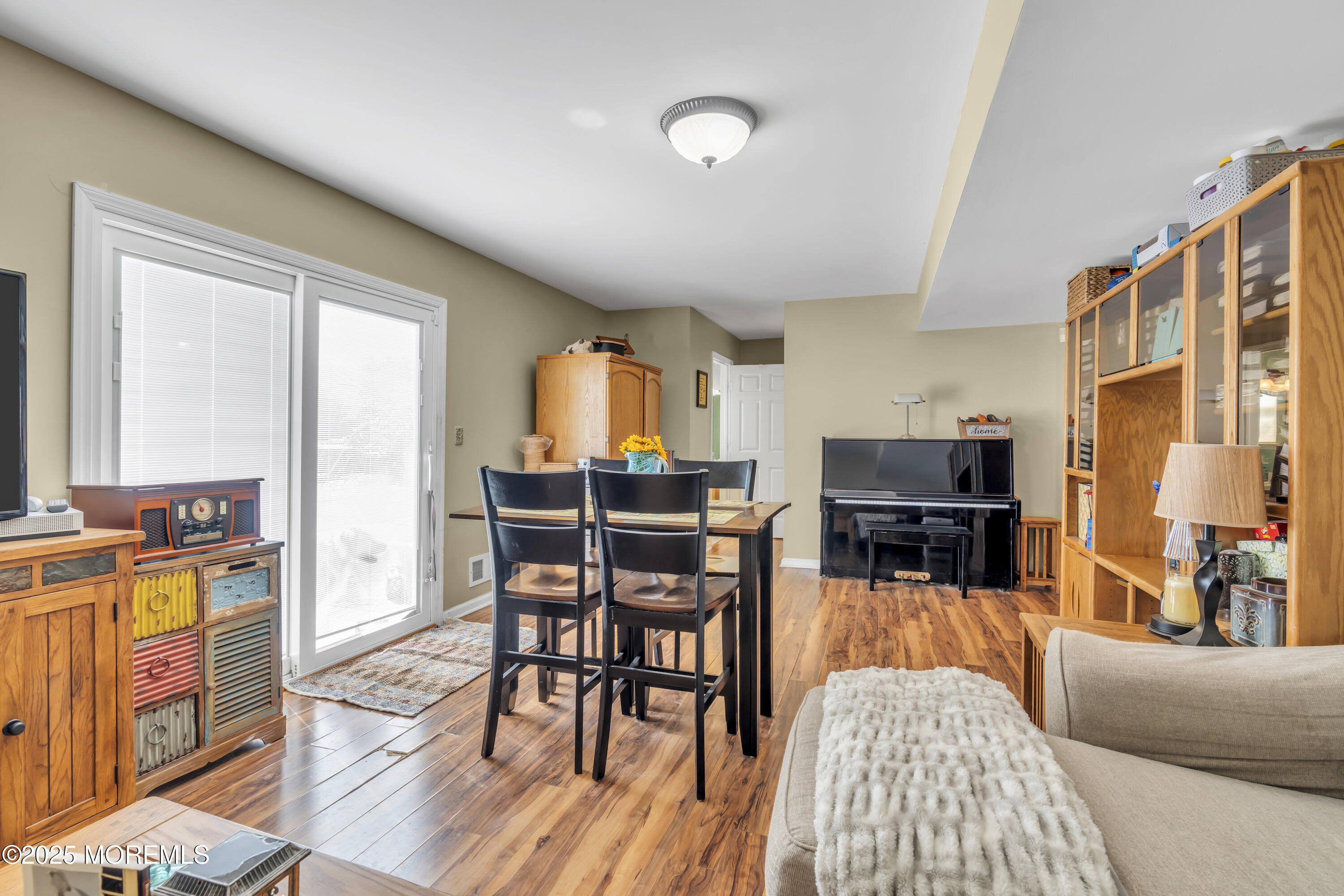 19 Sally Street Howell, NJ 07731 - Photo 20 of 31 a living room with furniture a dining table and chairs with wooden floor