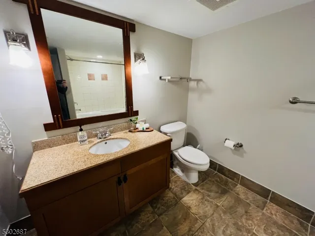 a bathroom with a granite countertop sink toilet and shower