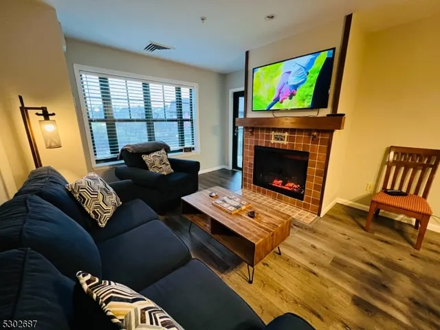 a dining room with furniture a rug a flat screen tv a rug and a chandelier
