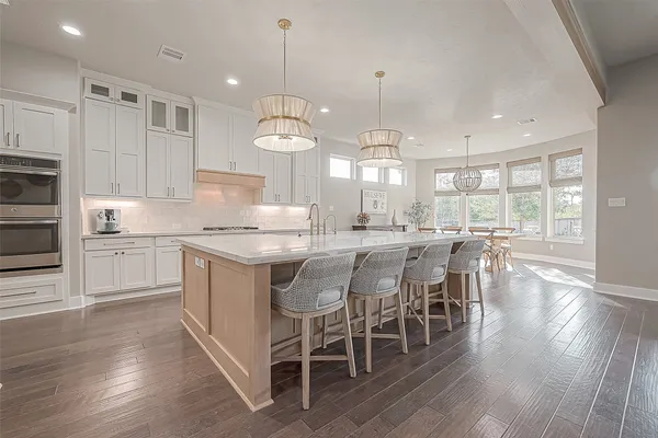 a large kitchen with a large counter top sink and stainless steel appliances