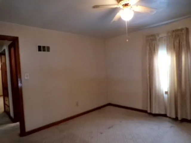 a view of an empty room with closet and a window