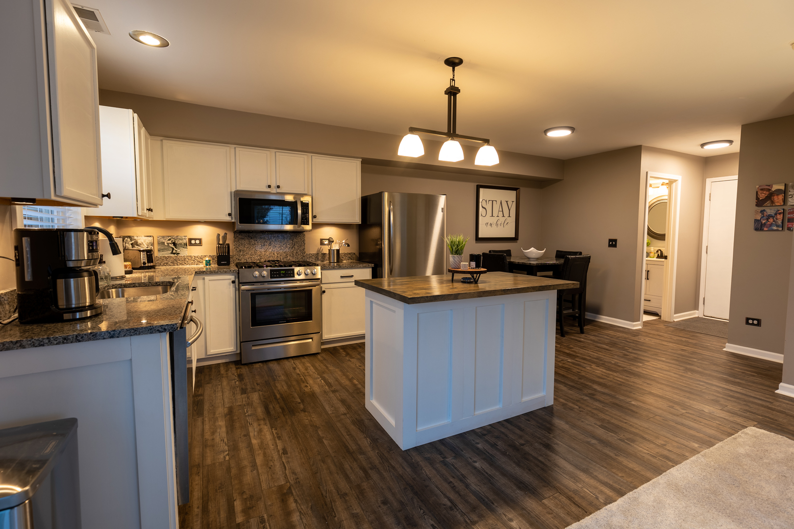 25101 Faraday Road Manhattan, IL 60442 - Photo 6 of 26 a kitchen with stainless steel appliances granite countertop wooden floors a stove and a center island