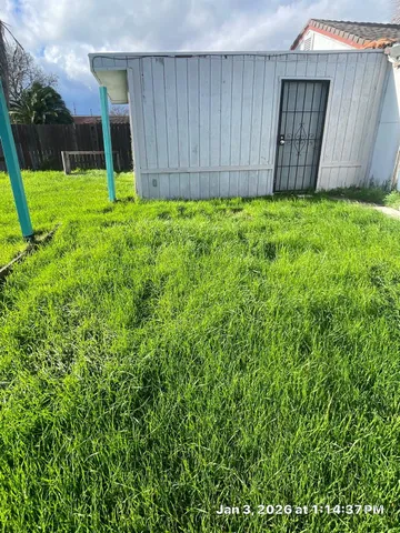 a view of backyard with potted plants and wooden fence
