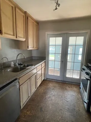 a kitchen with granite countertop a sink a stove and cabinets
