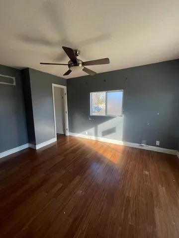 a view of empty room with wooden floor