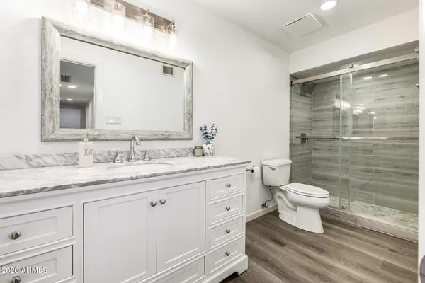 a bathroom with a granite countertop toilet sink and a mirror