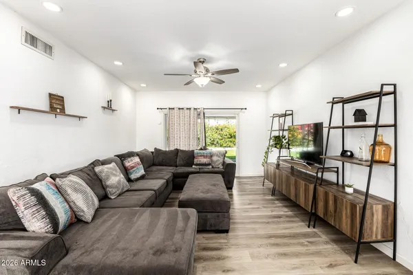 a living room with furniture a flat screen tv and a chandelier