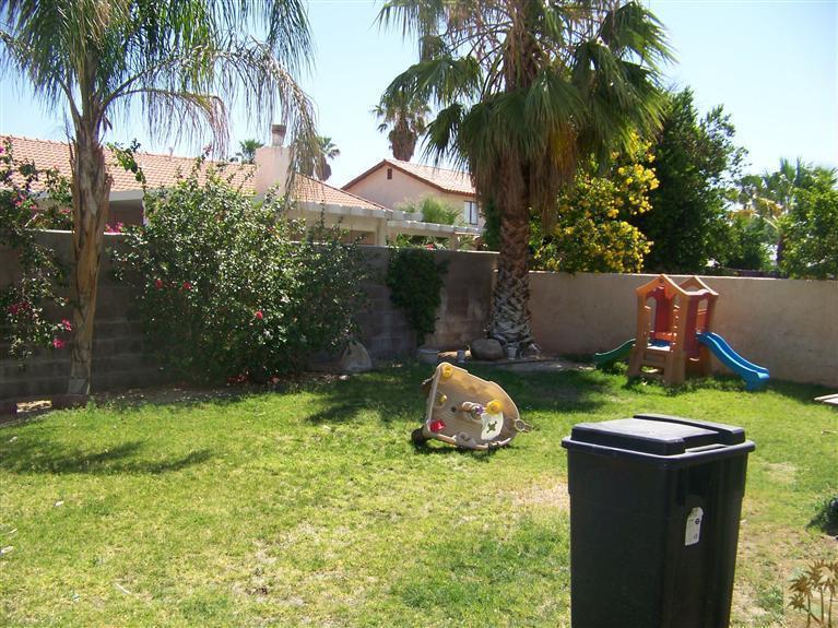 68220 Santelmo Road Cathedral City, CA 92234 - Photo 2 of 21 a backyard of a house with table and chairs potted plants and palm trees