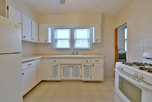 a kitchen with white cabinets and a stove