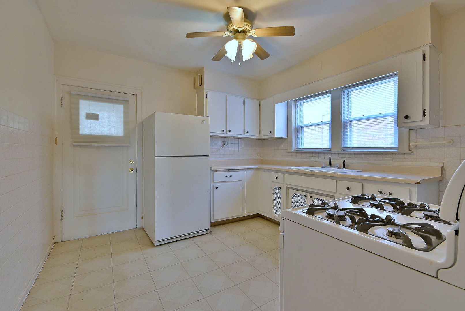 1835 Home Avenue Berwyn, IL 60402 - Photo 13 of 30 a kitchen with a refrigerator a sink cabinets and a window