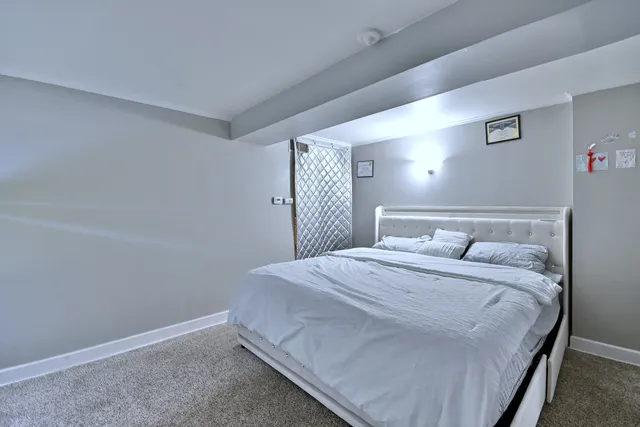 a bedroom with a bed and a large mirror