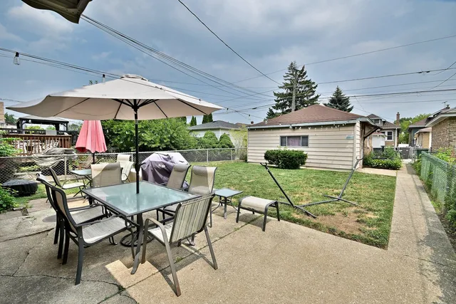 a patio with a table and chairs under an umbrella