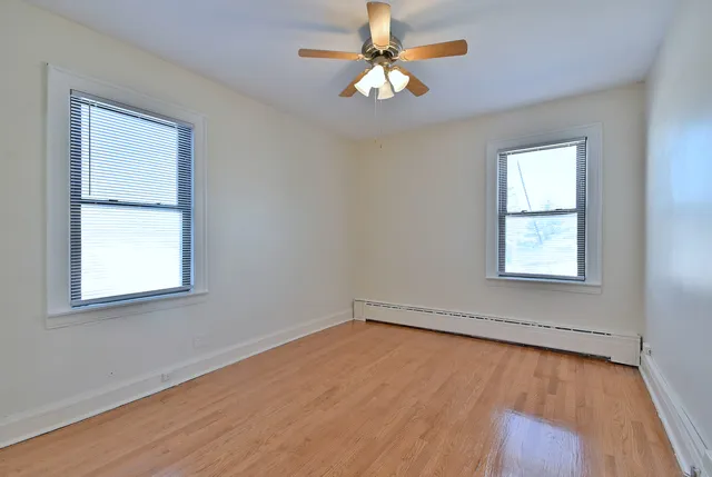 an empty room with a window and a fan